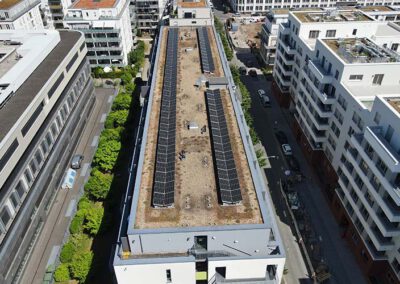 Drohnenaufnahme einer Photovoltaikanlage auf einem Flachdach in Frankfurt am Main – großflächige Solarmodule auf einem modernen Wohn- und Geschäftsgebäude für nachhaltige Energiegewinnung in urbaner Lage.