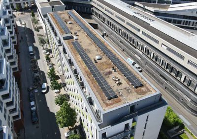 Drohnenaufnahme einer modernen Photovoltaikanlage auf einem Wohn- und Geschäftsgebäude in Frankfurt am Main – nachhaltige Solartechnik zur effizienten Stromerzeugung in urbaner Umgebung.
