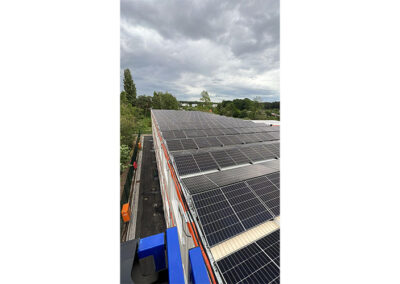 Drohnenaufnahme einer großflächigen Photovoltaikanlage auf einem modularen Gewerbegebäude – moderne Solarmodule zur nachhaltigen Stromerzeugung und energieeffizienten Versorgung eines Baustellenstandorts.