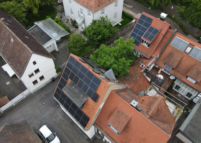 Senkrechte Drohnenaufnahme von Wohnhäusern mit Photovoltaikanlagen in Offenbach – Solarmodule auf traditionellen Hausdächern für energieeffiziente Stromerzeugung.