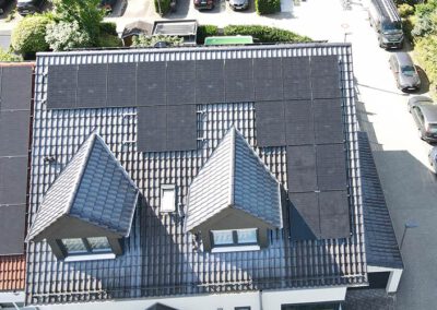 Drohnenaufnahme eines Wohnhauses mit vollflächiger Photovoltaikanlage in Frankfurt am Main – moderne Solarmodule auf dem Ziegeldach für nachhaltige Solarenergie und hohe Eigenstromversorgung.